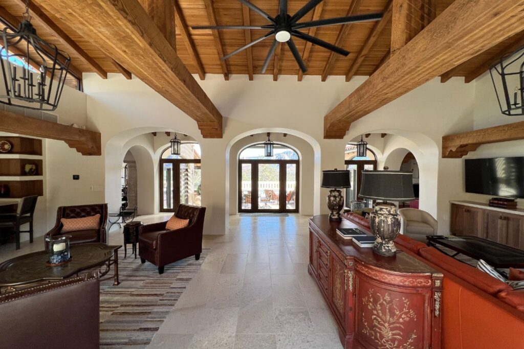 Living room with vaulted ceiling and exposed wooden beams, red an black furniture